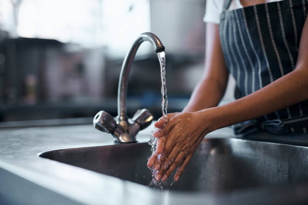 Good food starts with good hygiene Cropped shot of a woman washing her hands in the sink of a commercial kitchen tap water restaurant stock pictures, royalty-free photos & images