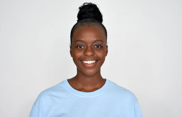 jovem afro-americana feliz usa olhar azul de camiseta para a câmera isolada em fundo cinza. uma garota étnica negra positiva com dentes brancos saudáveis, retrato sorridente dentário, de perto. - afro americano fotos - fotografias e filmes do acervo