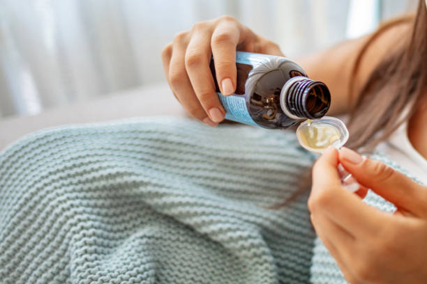 istock Anonymous sick female filling measuring spoon with cough syrup 1263847910
