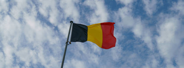 Flag of Belgium. Photography of Belgium flag. Blue sky with white fine clouds as background. Waving black, yellow and red colored flag. consul photos stock pictures, royalty-free photos & images