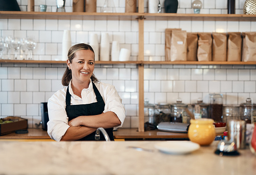 Portrait of a confident mature woman working behind the counter of a cafe