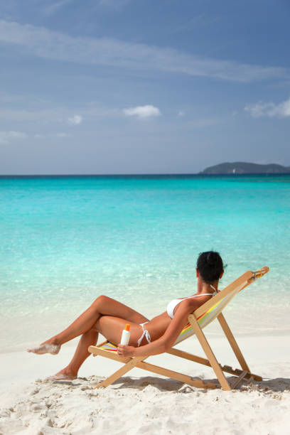 istock attractive woman applying sunscreen at a tropical beach 1263852475