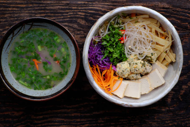 sopa caseira de macarrão vegano vietnamita, legumes coloridos, bolas de tofu, delicioso, nutrição, tigela de prato vegetariano saudável - indochina soup flag national flag - fotografias e filmes do acervo