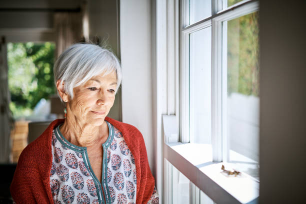 istock Senior woman standing alone at home lost in thought 1263853727