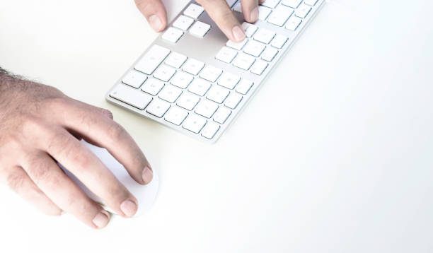 istock male hand clicking on a mouse and typing on a white keyboard on a white table 1263854036