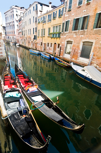Small canal with two gondolas in Venice, Italy.