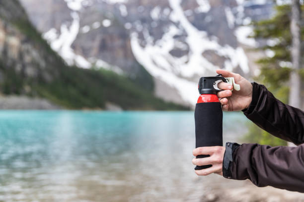 primo piano di una donna che tiene la mano spray per orsi nella foresta durante le escursioni al moraine lake, banff national park, canada - lake louise national park landscape forest foto e immagini stock