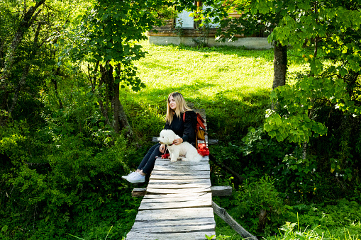 Happy female with his pet enjoying on wooden bridge