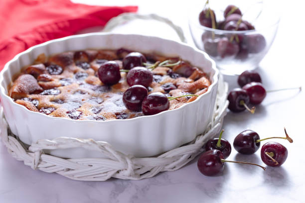 Traditional french cherry clafoutis with cherry on white marble Cherry clafoutis - traditional French sweet fruit dessert clafoutis stock pictures, royalty-free photos & images