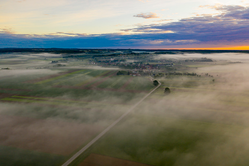 Drone view of dense mist on fields and village