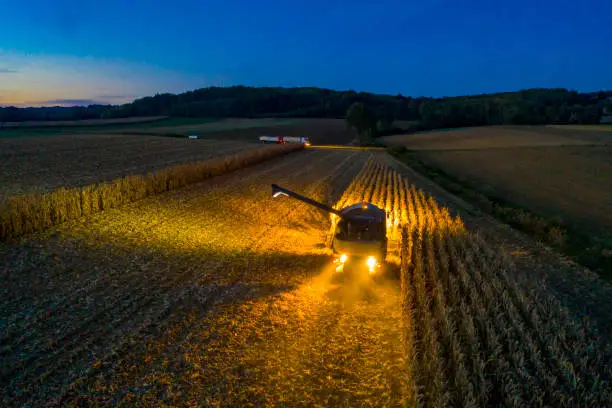 Photo of Aerial view: Combine harvester at work at dusk
