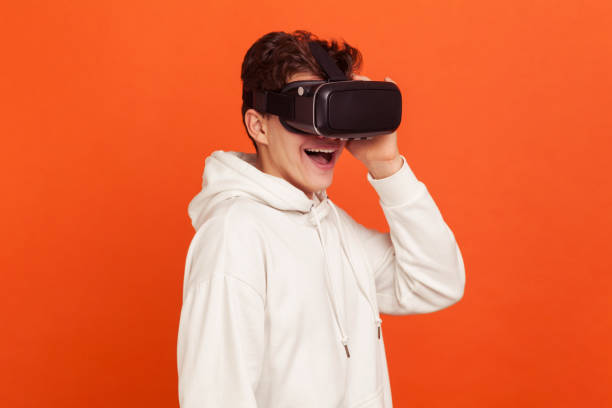 adolescente espantado em moletom branco casual com capuz com experiência com fone de ouvido de realidade virtual, simulação 3d, alta tecnologia - hood men portrait profile - fotografias e filmes do acervo