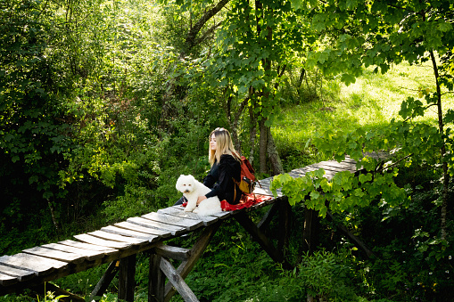 Happy female with his pet enjoying on wooden bridge