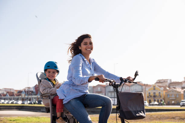 Mother riding on a bicycle with young kid Eco-friendly Family.  Mother riding on a bicycle with young kid 8564 stock pictures, royalty-free photos & images