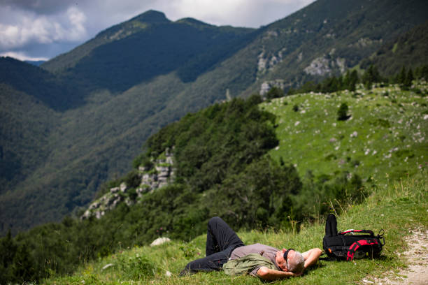 istock Active Senior Man Lying Down in Grass on a Hiking Trip in the Hills 1263862515
