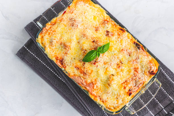 Traditional Italian Baked Pasta with Chicken Garnished with Basil Leaves Directly from Above Horizontal Photo Baked Chicken Pasta in a Casserole Garnished with Basil Leaves Directly Above Photo pasta casserole stock pictures, royalty-free photos & images