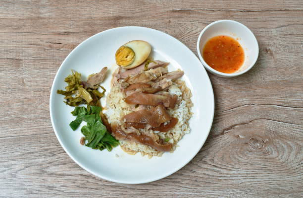 boiled pork leg slice in black Chinese herb soup with egg dipping spicy and sour chili sauce topping rice boiled pork leg slice in black Chinese herb soup with egg dipping spicy and sour chili sauce topping rice on plate pork hock stock pictures, royalty-free photos & images