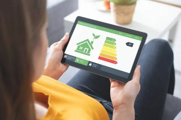 Photo of Energy efficiency mobile app on screen, eco house