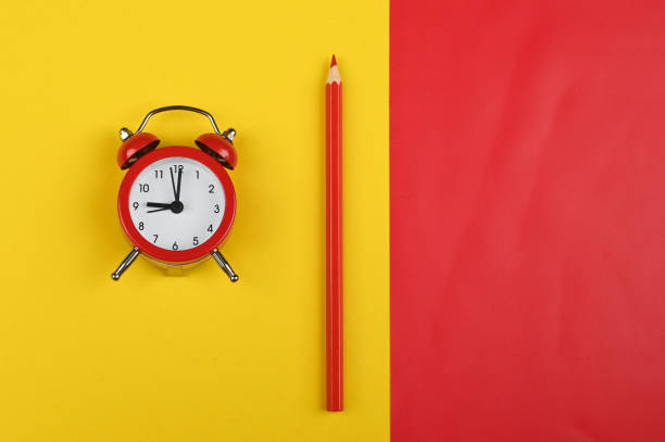 istock red alarm clock with a pencil on a red-yellow background 1263865805