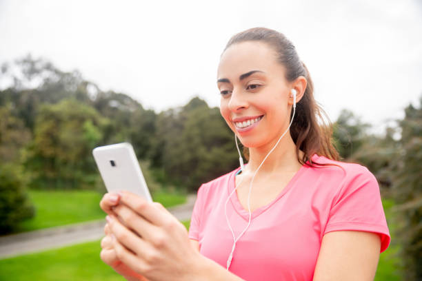 istock Woman exercising outdoors and using an app on her cell phone 1263867124