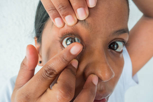 istock Woman putting on contact lenses 1263867842