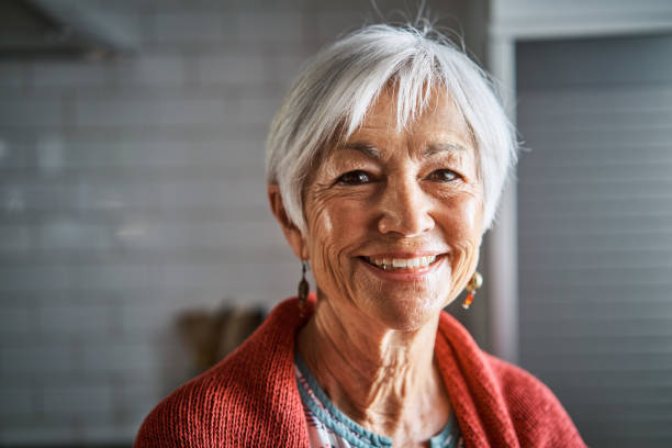 istock Senior woman smiling while standing in her kitchen at home 1263870087