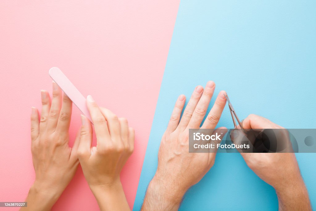 Woman Hand Polishing Nail With File Man Hand Using Scissors For Cutting  Nails Difference Between Male And Female Grooming Pastel Blue Pink Table  Background Closeup Top Down View Two Sides Stock Photo -