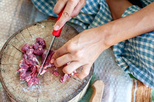 Mujer cortando carne de cabra para una alimentación saludable photo