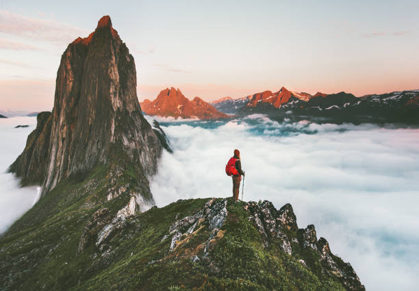 istock Traveler on cliff over clouds exploring sunset Segla mountain alone hiking adventure journey outdoor Norway vacations traveling lifestyle weekend getaway 1263876444