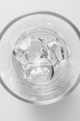 Top view of glass filled with ice cubes on white background