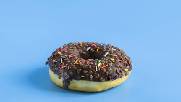 istock A fresh, delicious doughnut covered in chocolate icing on a blue background. Close up 1263877596