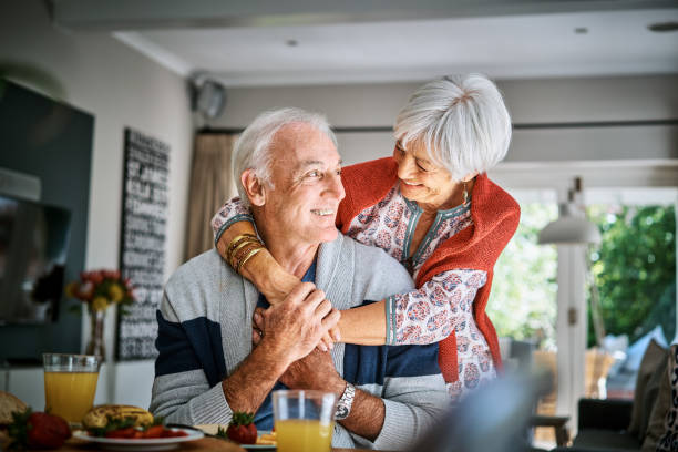 istock Smiling senior woman hugging her husband during breakfast 1263878861