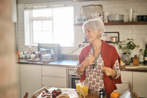 istock Smiling senior woman talking with her husband in their kitchen 1263879331