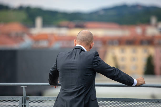 Man in suit is admiring a view of a city.