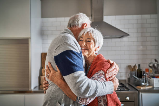 istock Smiling senior couple hugging each other in their kitchen 1263880512
