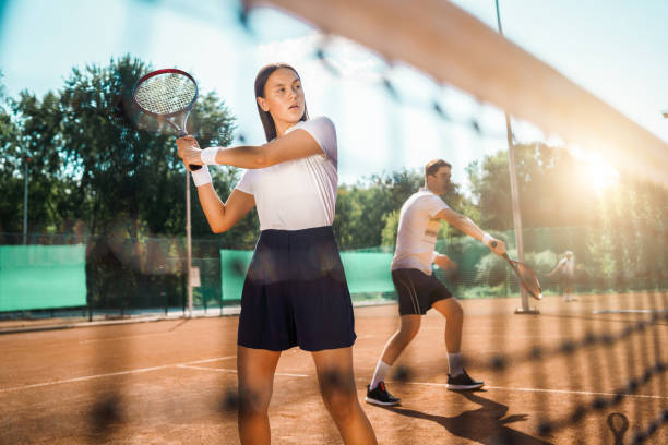 istock Young couple playing doubles tennis 1263880606
