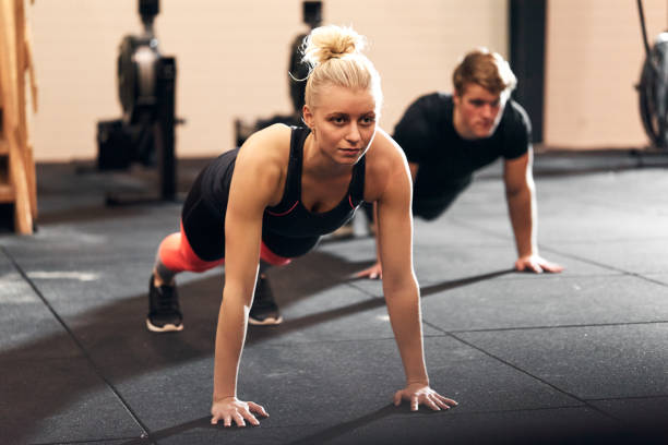 istock Young woman doing pushups during a class at the gym 1263881739