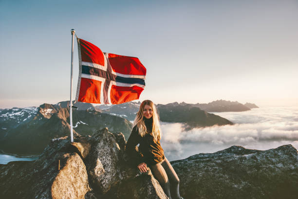 donna e norvegia bandiera sulla montagna cima ragazza bionda in viaggio godendo vista escursioni avventura vacanze stile di vita attivo all'aperto - norwegian flag norway flag freedom foto e immagini stock