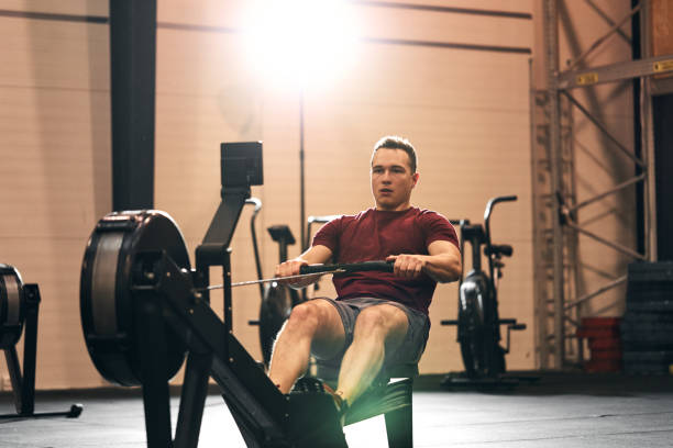 istock Young man exercising on a gym rowing machine 1263881950