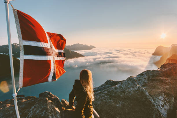 donna che si gode la vista sulle montagne al tramonto e la bandiera norvegese sulla migliore vita di viaggio escursioni di stile di vita vacanze avventurose all'aperto - norwegian flag norway flag freedom foto e immagini stock