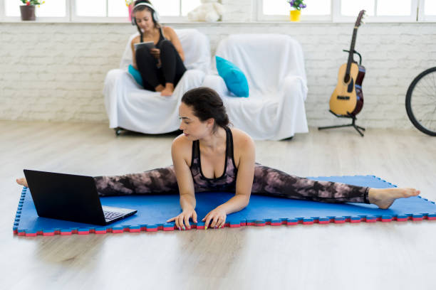 eine frau, die yoga im wohnzimmer macht. - the splits flexibility yoga teenage girls stock-fotos und bilder