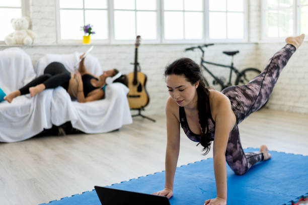 eine frau, die yoga im wohnzimmer macht. - the splits flexibility yoga teenage girls stock-fotos und bilder