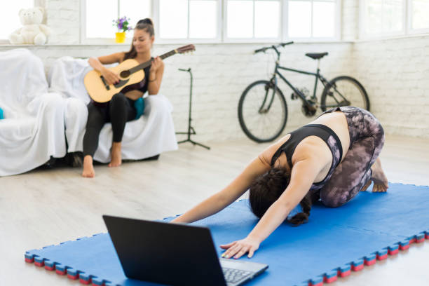 eine frau, die yoga im wohnzimmer macht. - the splits flexibility yoga teenage girls stock-fotos und bilder