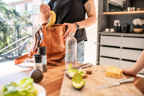 Woman putting her fruit snack in a bag Woman putting her fruit snack in a bag bag lunch stock pictures, royalty-free photos & images