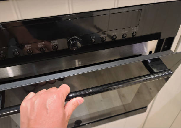 istock a hand opening a gas oven door 1263886236