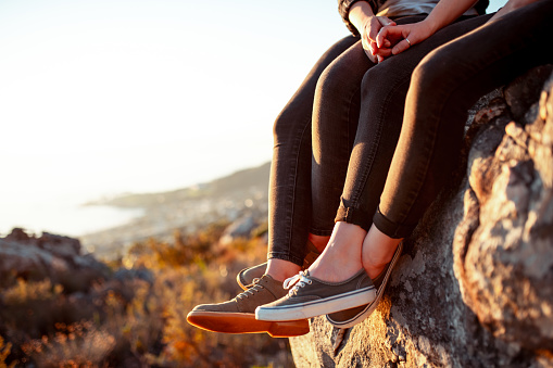 Photo of women sitting on the edge of the mountain