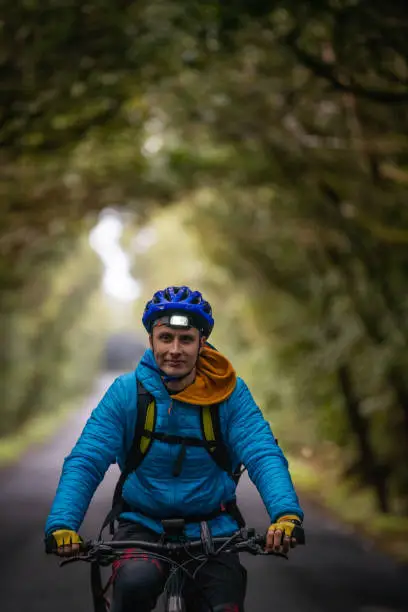 Photo of Close up of man cycling through tree tunnel, La Gomera, Canary Islands, Spain