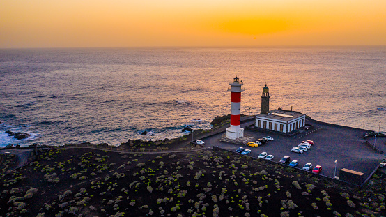 View of sea and lighthouse at sunset