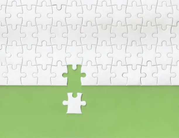 Photo of Green background made from white puzzle pieces and copy space for content