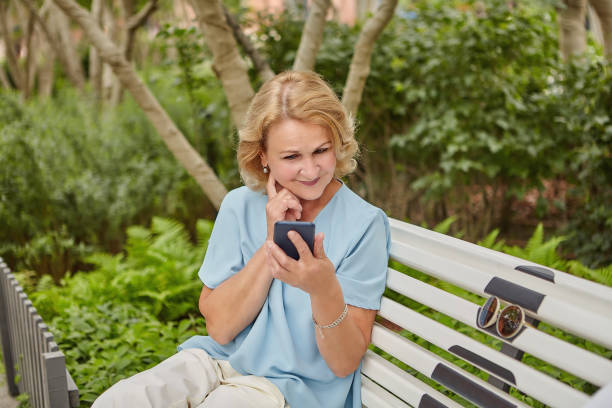 istock Elderly pretty white woman with cellphone. 1263891580